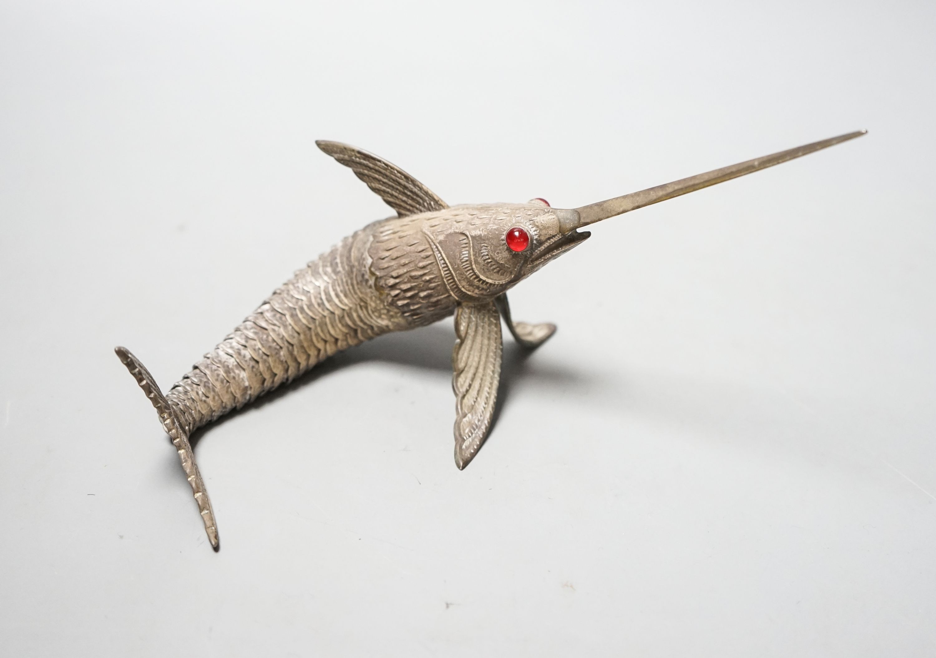 A 20th century Spanish articulated white metal model of a swordfish, with red glass eyes, approx. 26.5cm, gross weight 118 grams.